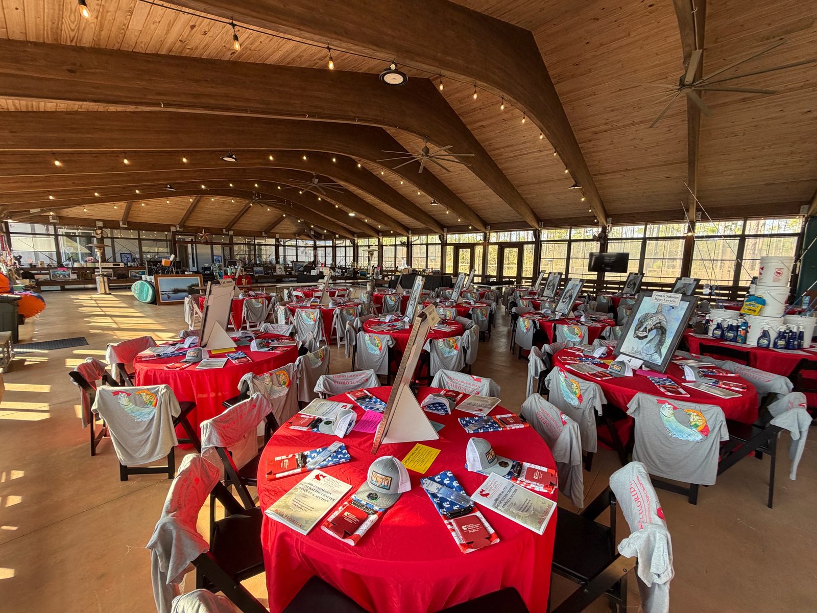 Close-up of gala table setting with linen, place cards, and silent auction items