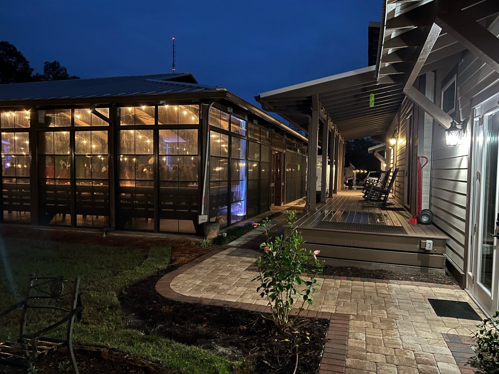 Paver walkway between the cabin porch and the glowing pavilion at night