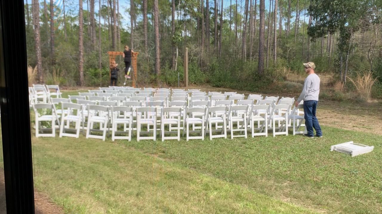 White ceremony chairs arranged on the Point Preserve lawn at sunset