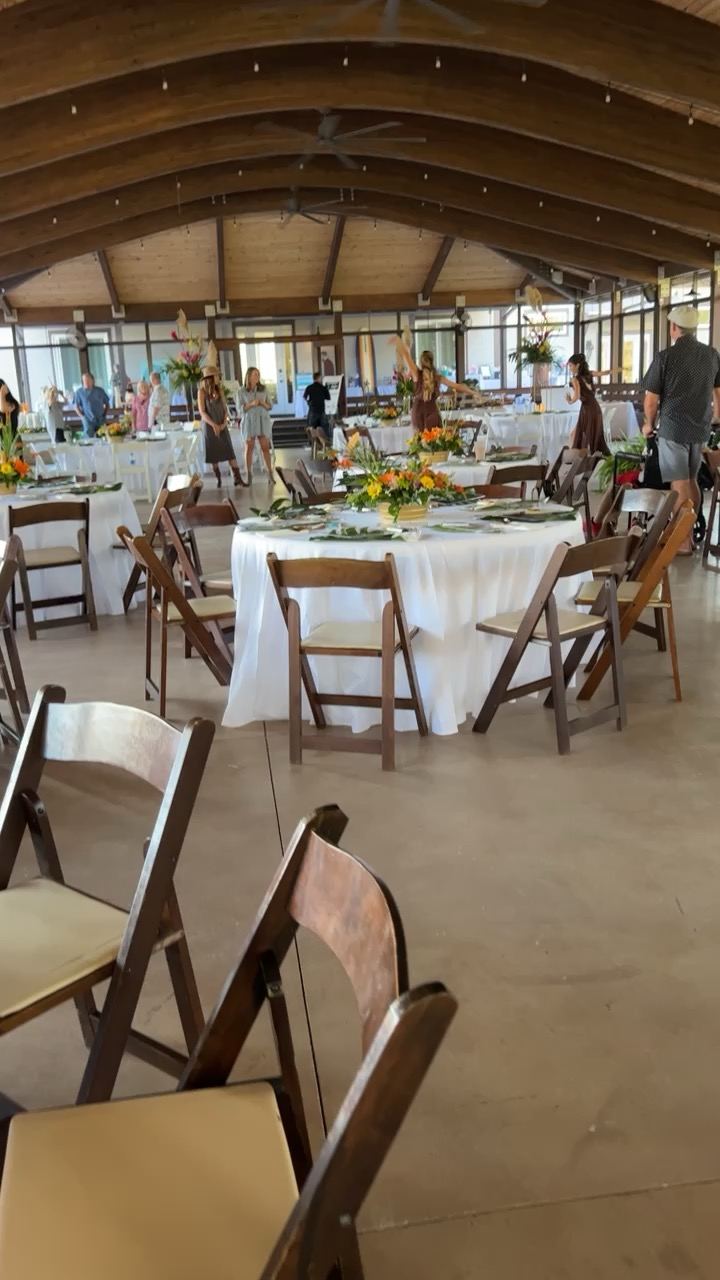 Reception tables being arranged inside the pavilion under warm interior lighting